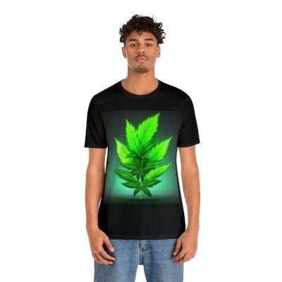 Black t-shirt with large glowing green leaf graphic, modeled by young man, casual style