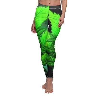 Woman wearing bright green herbal leaf print leggings on a white background.