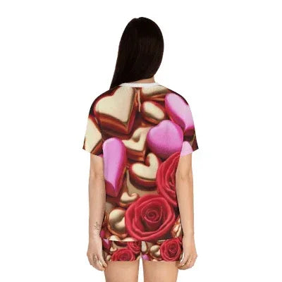 Woman wearing short pyjamas with pink hearts and red rose print, back view