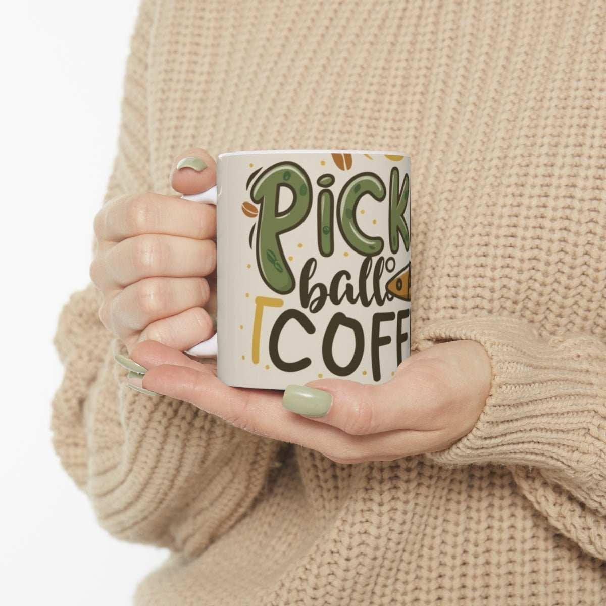 Woman in beige sweater holding Pickleball Coffee ceramic mug with green lettering