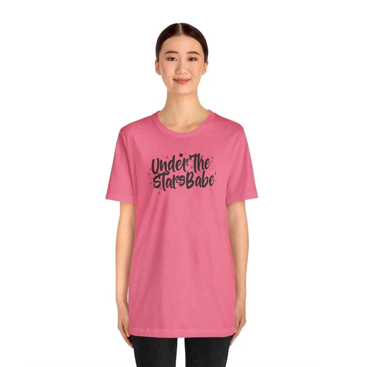 Woman in pink graphic t-shirt with 'Under the Stars Babe' text, celestial style