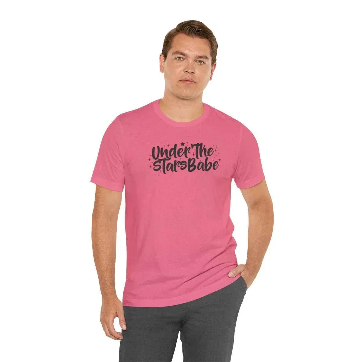 Man wearing pink graphic t-shirt with celestial 'Under The Stars Babe' text design